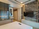 Modern bedroom with marble wall decor and mounted TV