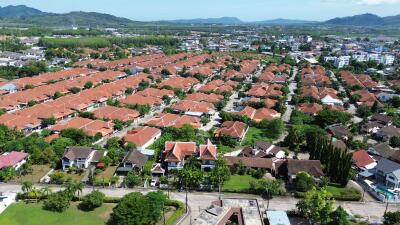 Aerial view of a residential neighborhood with numerous houses featuring red-tiled roofs