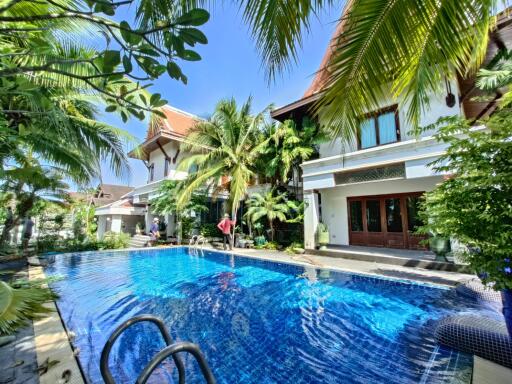 Outdoor area with a pool and lush greenery