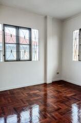 Unfurnished bedroom with wooden flooring and large windows