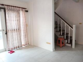 Living room with staircase and curtains