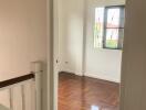 Empty bedroom with wooden floor and window