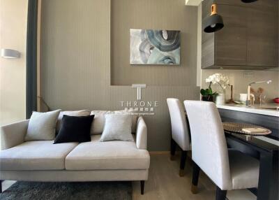 Modern living area with a sofa, dining table, and kitchen cabinet
