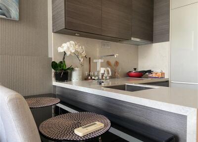 Modern kitchen with a compact design featuring a breakfast bar, built-in appliances, and stylish cabinetry