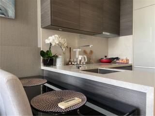 Modern kitchen with a compact design featuring a breakfast bar, built-in appliances, and stylish cabinetry