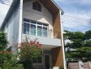 Modern two-story house with a balcony and garden