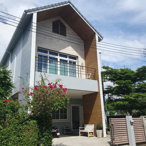 Modern two-story house with a balcony and garden