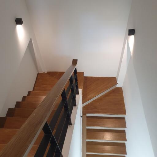 Modern staircase with wooden steps and sleek railing