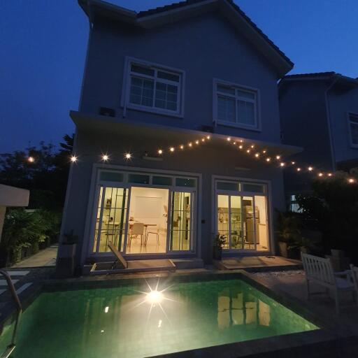 Exterior view of a house with a pool at night