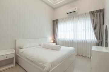 Modern bedroom with white decor, bed, curtains and air conditioning