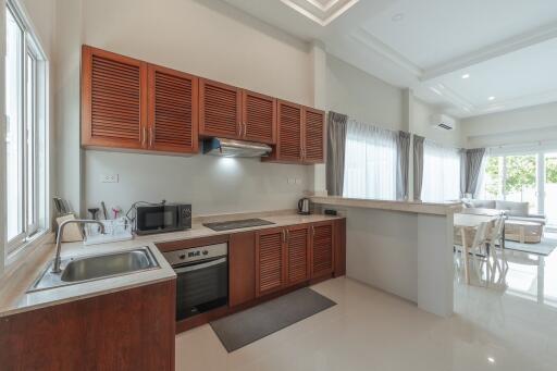 Modern kitchen with wooden cabinets and a connected dining area