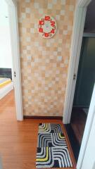 Hallway with clock and colorful rug