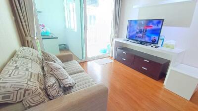 Cozy living room with a sofa, TV unit, and balcony access