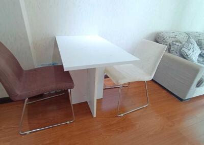 A minimalistic living room with a small dining table and chairs