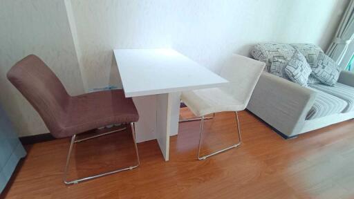 A minimalistic living room with a small dining table and chairs