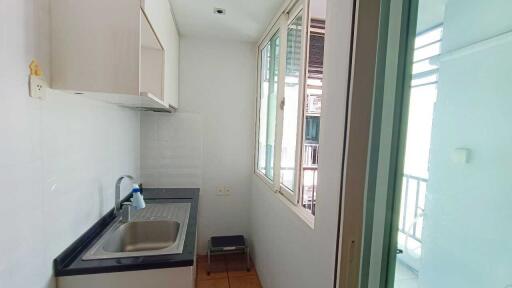 Compact kitchen with sink, window, and storage cabinets