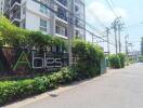 Front entrance of a residential building with well-maintained greenery