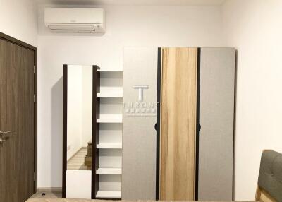 Modern bedroom with wardrobe, shelves, and air conditioning unit