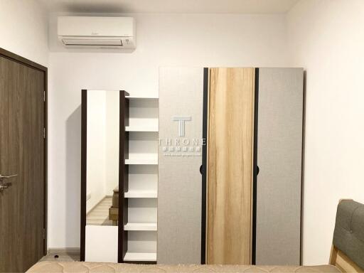 Modern bedroom with wardrobe, shelves, and air conditioning unit