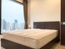 City view bedroom with large window and comfortable bed