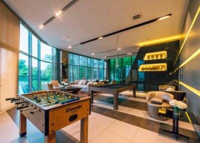 Spacious recreational room with large windows, foosball table, and cozy seating area