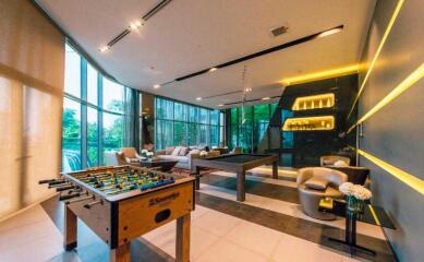 Spacious recreational room with large windows, foosball table, and cozy seating area