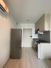 Modern kitchen with fridge, washing machine, and cabinets