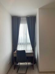 Small working/study area with chair and desk by window with curtains