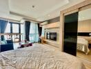 Spacious and modern bedroom with large windows and a separate seating area