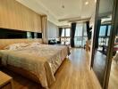 Spacious bedroom with wooden flooring, large bed, and ample natural light