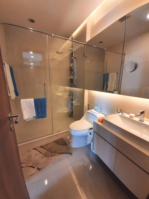 Modern bathroom with glass shower, vanity with sink, and toilet