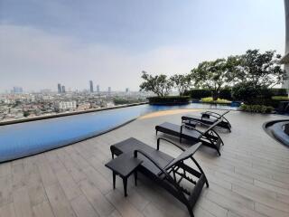 Outdoor infinity pool with city view and lounge chairs