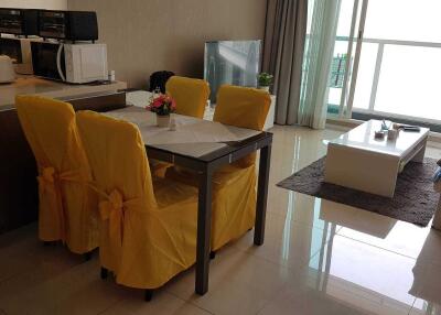 Modern living and dining area with yellow chair covers and balcony view