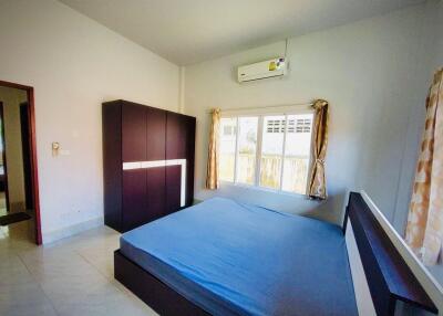 Spacious bedroom with large window and air conditioning