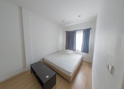 minimalist bedroom with a bed, side table, and window