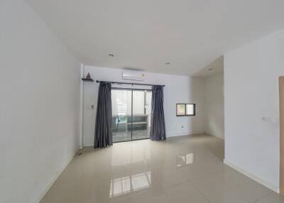 Spacious living room with large window and sliding glass door.