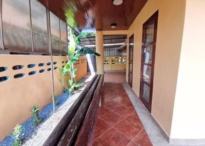 Covered outdoor hallway with tiled floor and ceiling lights