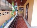 Covered outdoor hallway with tiled floor and ceiling lights