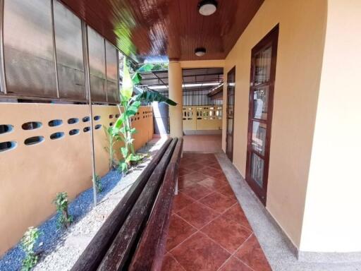 Covered outdoor hallway with tiled floor and ceiling lights