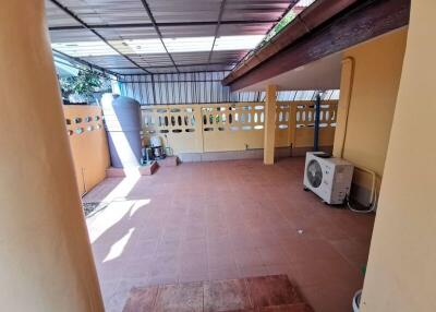 Covered outdoor patio with part shelter and tiled floor.