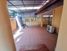 Covered outdoor patio with part shelter and tiled floor.