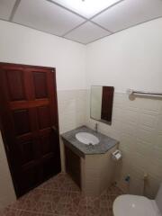 Bathroom with tiled walls, granite countertop and wooden door