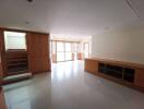 Spacious living room with wooden cabinetry and large windows