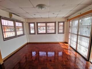 spacious living room with polished wooden floor and large windows