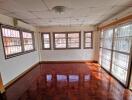 spacious living room with polished wooden floor and large windows