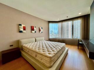 Modern bedroom with large windows and a city view