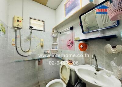 Bathroom with white sink, toilet, shower, and water heater