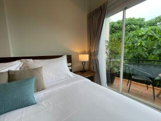 Bright bedroom with sliding glass door to a balcony