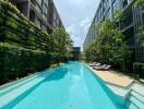 View of a swimming pool with surrounding greenery and modern buildings