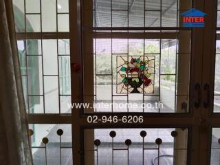 Closed doors leading to a balcony with stained glass panel